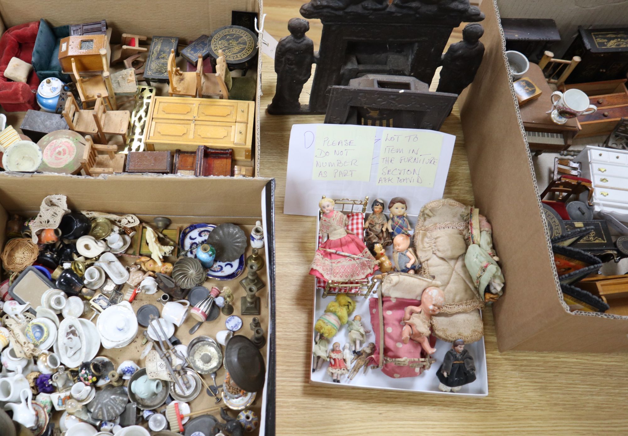 A collection of dolls and dolls house furniture displayed in room settings in a pine cupboard, width 84cm, depth 36cm, height 132cm